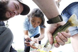 Photo of students holding a fish. Link to Closely Held Business Stock.